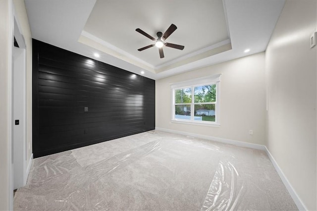 spare room featuring ceiling fan, a tray ceiling, carpet floors, baseboards, and recessed lighting