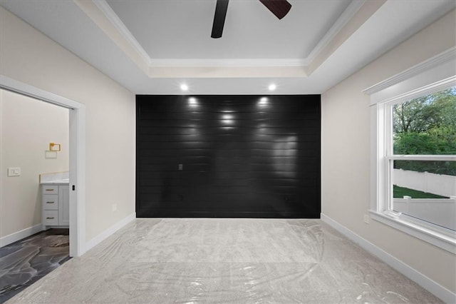 carpeted empty room featuring a ceiling fan, a tray ceiling, recessed lighting, baseboards, and ornamental molding