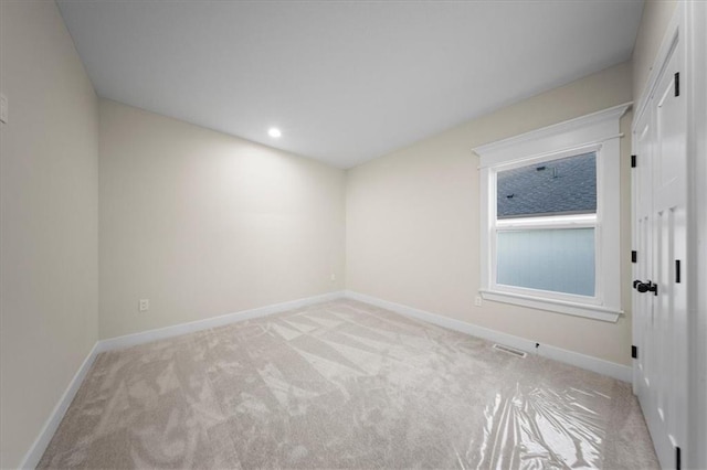 empty room featuring light colored carpet, baseboards, and recessed lighting