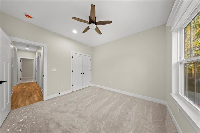 unfurnished bedroom featuring carpet flooring, baseboards, recessed lighting, ceiling fan, and a closet