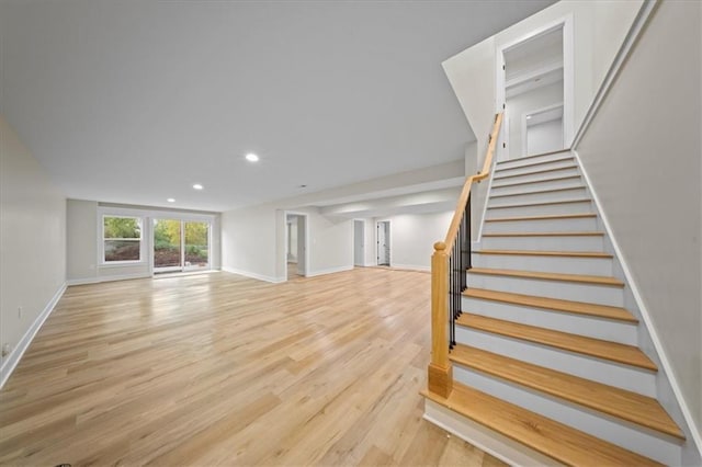 stairs featuring wood finished floors, baseboards, and recessed lighting