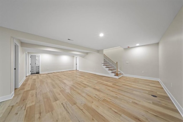 finished below grade area featuring stairs, light wood-type flooring, baseboards, and recessed lighting