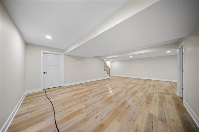 finished below grade area featuring wood finished floors, stairway, baseboards, and recessed lighting