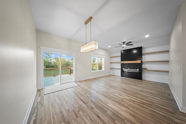 unfurnished living room featuring baseboards, wood finished floors, a ceiling fan, a glass covered fireplace, and recessed lighting