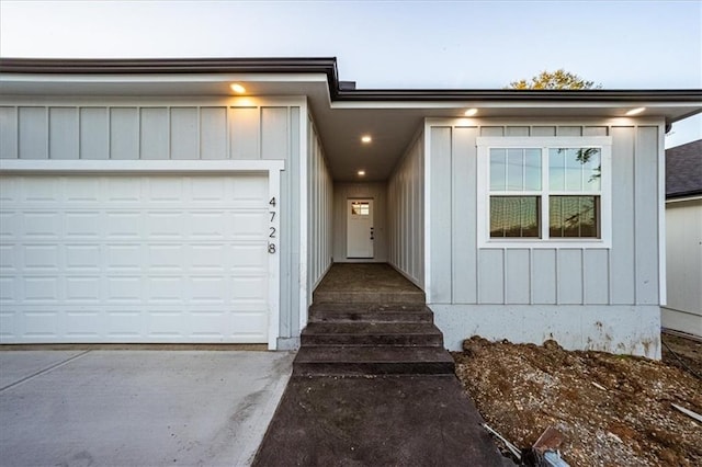 view of front of home with concrete driveway, board and batten siding, and a garage