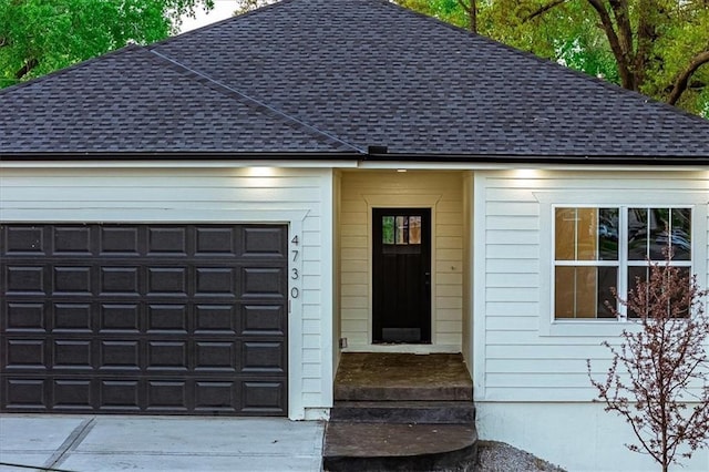view of front of home with roof with shingles, a garage, and concrete driveway