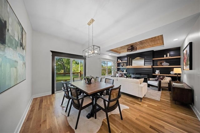 dining room featuring baseboards, light wood-style flooring, and a chandelier