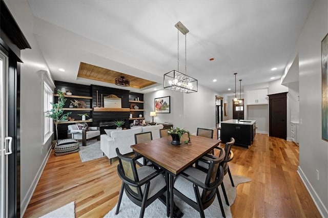 dining space with light wood-style flooring, baseboards, recessed lighting, and a chandelier