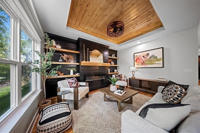 living area featuring a tray ceiling, wood finished floors, and wood ceiling