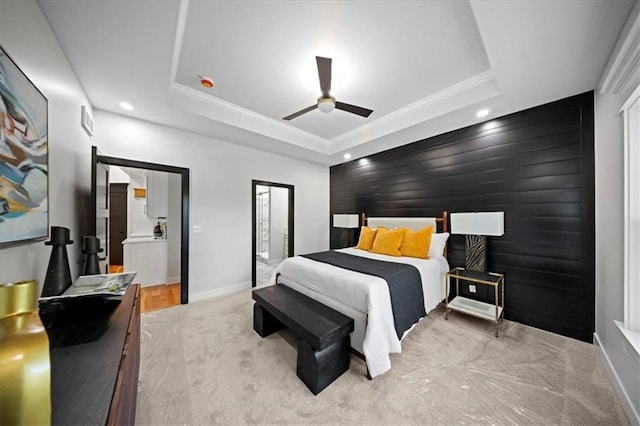 bedroom with carpet floors, an accent wall, a tray ceiling, recessed lighting, and baseboards