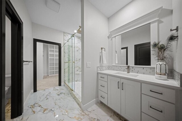 full bath with marble finish floors, a marble finish shower, vanity, baseboards, and tasteful backsplash