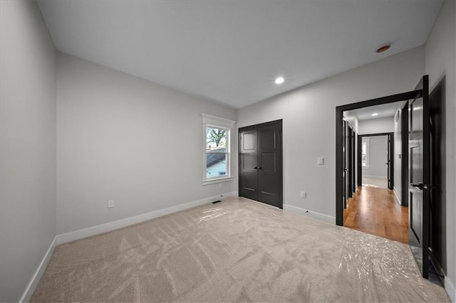 unfurnished bedroom featuring carpet, baseboards, and recessed lighting