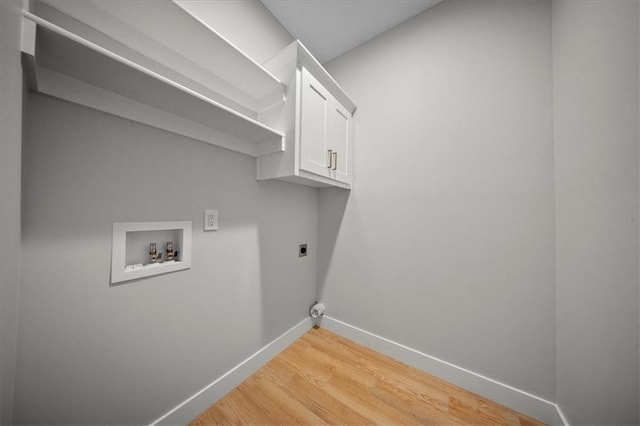 laundry room featuring electric dryer hookup, baseboards, cabinet space, hookup for a washing machine, and light wood-type flooring