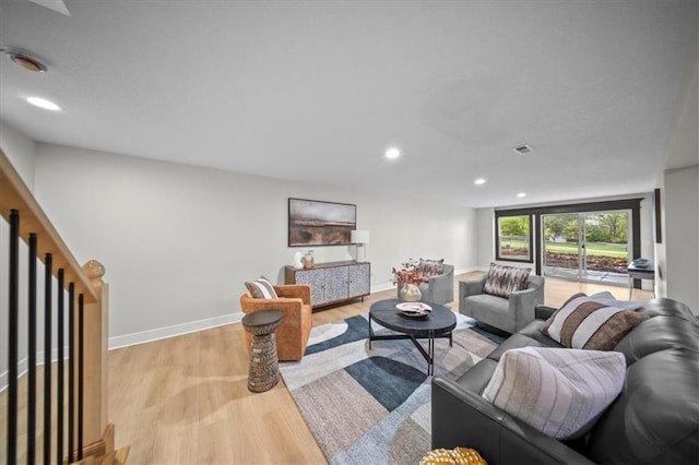 living room with light wood-type flooring, recessed lighting, and baseboards