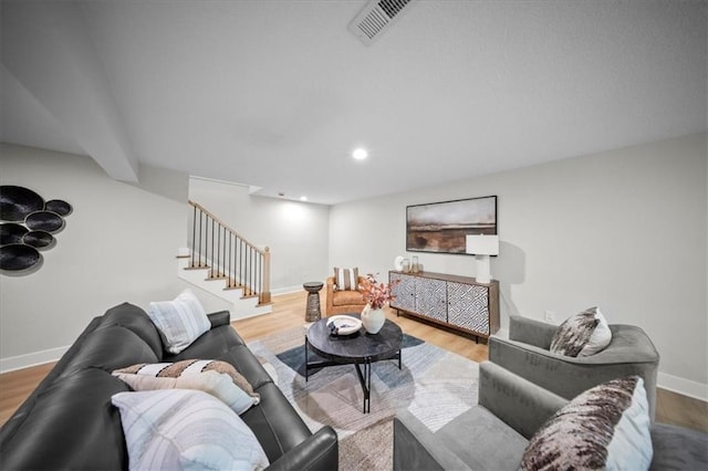 living room featuring stairway, baseboards, wood finished floors, and recessed lighting