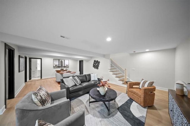 living room with stairway, light wood-style floors, baseboards, and recessed lighting