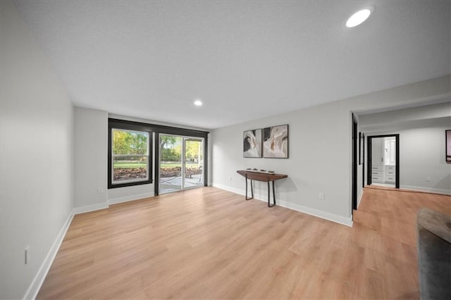 unfurnished living room featuring light wood-style flooring, recessed lighting, and baseboards