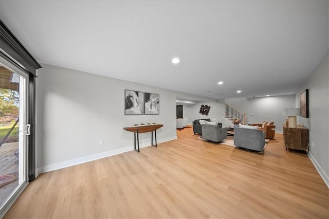 living room featuring stairs, light wood-style flooring, recessed lighting, and baseboards