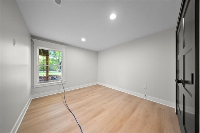 empty room featuring light wood finished floors, baseboards, and recessed lighting