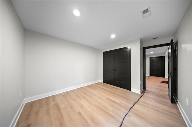 unfurnished bedroom featuring light wood-style flooring, baseboards, and recessed lighting