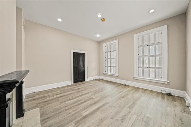 unfurnished living room featuring baseboards, recessed lighting, and light wood-style flooring