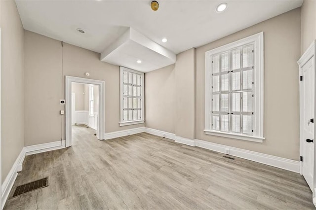 empty room featuring recessed lighting, baseboards, visible vents, and wood finished floors