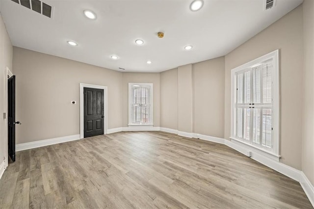 spare room with baseboards, recessed lighting, and wood finished floors