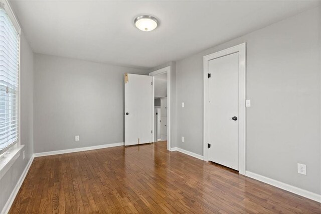 unfurnished bedroom featuring baseboards and hardwood / wood-style floors