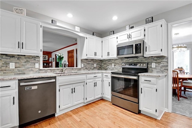 6600 W 125th Ter, Overland Park, KS 66209 - kitchen with stainless steel appliances, a sink, white cabinets, light wood-style floors, and recessed lighting