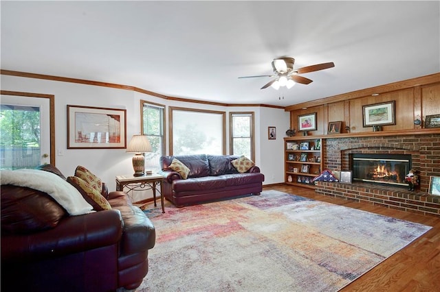 6600 W 125th Ter, Overland Park, KS 66209 - living area with healthy amount of natural light, wood finished floors, ceiling fan, a brick fireplace, and crown molding
