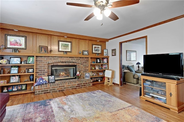 6600 W 125th Ter, Overland Park, KS 66209 - living room with ornamental molding, a ceiling fan, a brick fireplace, wood finished floors, and wooden walls