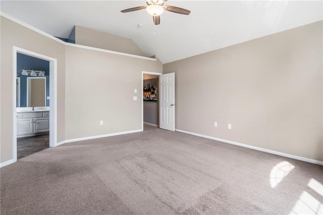 unfurnished bedroom with a ceiling fan, vaulted ceiling, baseboards, ensuite bathroom, and carpet flooring