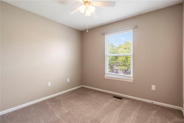 spare room with baseboards, visible vents, light carpet, and ceiling fan