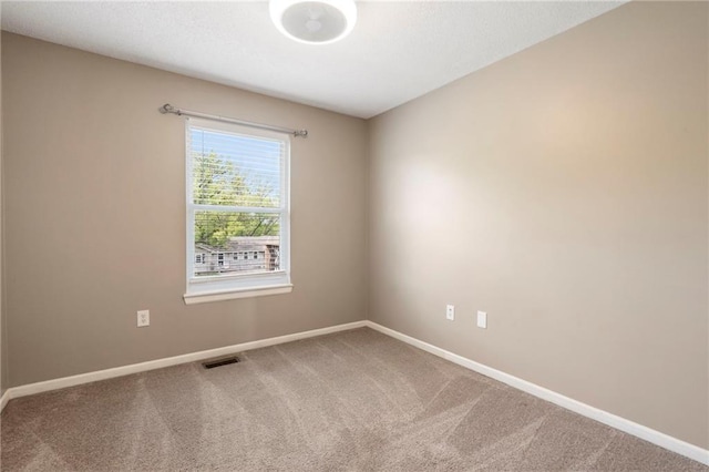 carpeted spare room with baseboards and visible vents