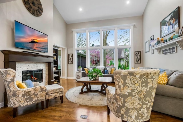 10863 S Cedar Niles Cir, Olathe, KS 66061 - living room with a towering ceiling, wood finished floors, a stone fireplace, recessed lighting, and baseboards