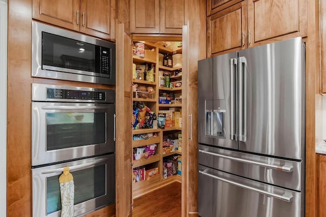 10863 S Cedar Niles Cir, Olathe, KS 66061 - kitchen with appliances with stainless steel finishes, brown cabinets, and wood finished floors