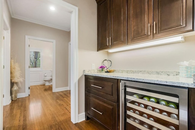 10863 S Cedar Niles Cir, Olathe, KS 66061 - indoor dry bar featuring wine cooler, dark wood-style flooring, ornamental molding, and baseboards