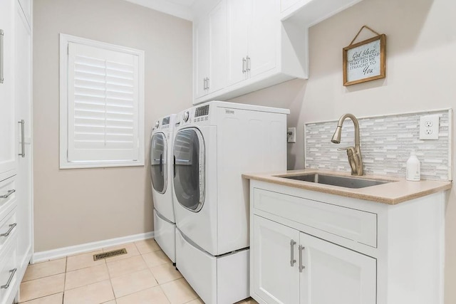 10863 S Cedar Niles Cir, Olathe, KS 66061 - clothes washing area featuring washing machine and clothes dryer, cabinet space, baseboards, and light tile patterned floors