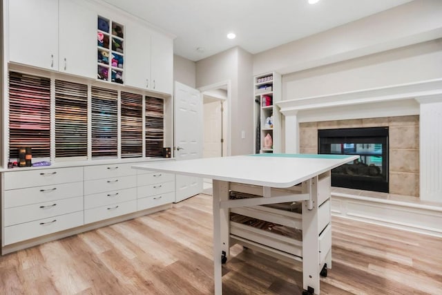 10863 S Cedar Niles Cir, Olathe, KS 66061 - kitchen featuring light wood-style floors, white cabinets, a tiled fireplace, open shelves, and recessed lighting