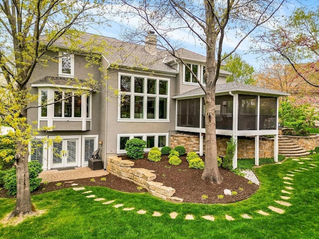 10863 S Cedar Niles Cir, Olathe, KS 66061 - back of house with a sunroom, stucco siding, a chimney, and a lawn