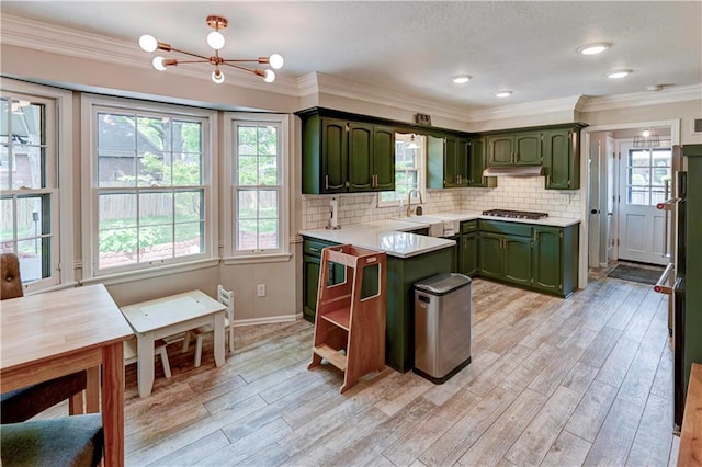 1400 SW 8th Ter, Lees Summit, MO 64081 - kitchen featuring green cabinets, light countertops, a chandelier, gas cooktop, and light wood-type flooring