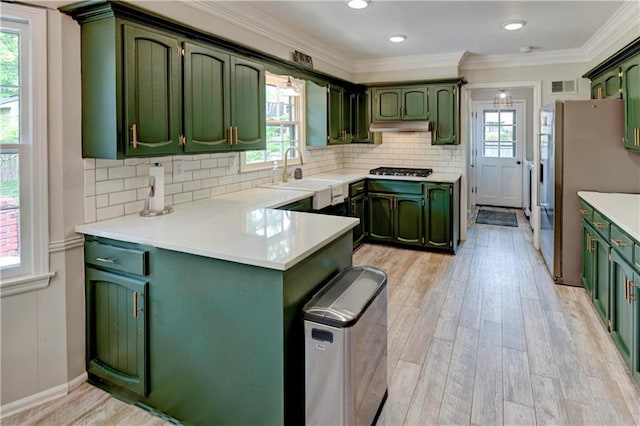 1400 SW 8th Ter, Lees Summit, MO 64081 - kitchen featuring green cabinetry, a sink, a peninsula, under cabinet range hood, and ornamental molding