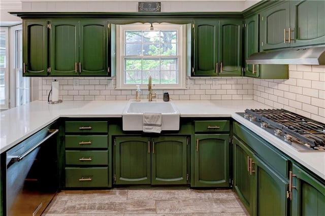 1400 SW 8th Ter, Lees Summit, MO 64081 - kitchen with appliances with stainless steel finishes, green cabinets, a sink, under cabinet range hood, and tasteful backsplash