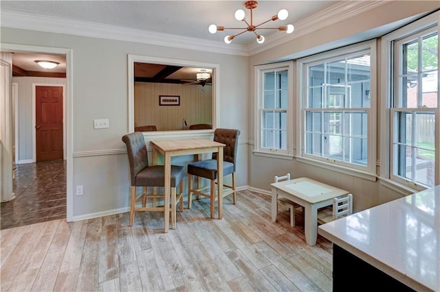 1400 SW 8th Ter, Lees Summit, MO 64081 - dining area with light wood-style flooring, ornamental molding, a chandelier, baseboards, and wooden walls