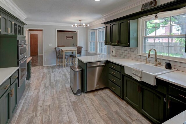 1400 SW 8th Ter, Lees Summit, MO 64081 - kitchen with dishwasher, green cabinets, a sink, a chandelier, and a peninsula