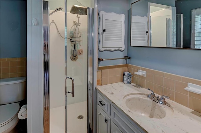 1400 SW 8th Ter, Lees Summit, MO 64081 - bathroom featuring tile walls, a shower stall, toilet, vanity, and wainscoting