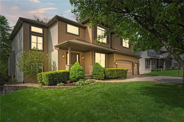view of front of home with an attached garage, concrete driveway, stucco siding, and a front yard