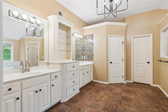 full bath featuring an inviting chandelier, a shower stall, a sink, and two vanities