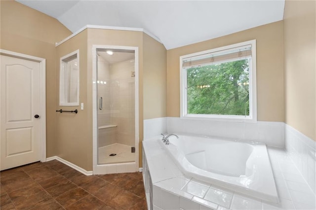 bathroom featuring a garden tub, baseboards, vaulted ceiling, and a shower stall