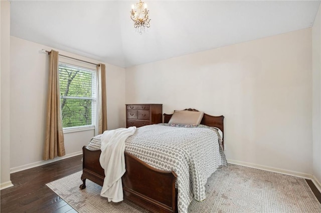 bedroom with baseboards, vaulted ceiling, hardwood / wood-style floors, and an inviting chandelier